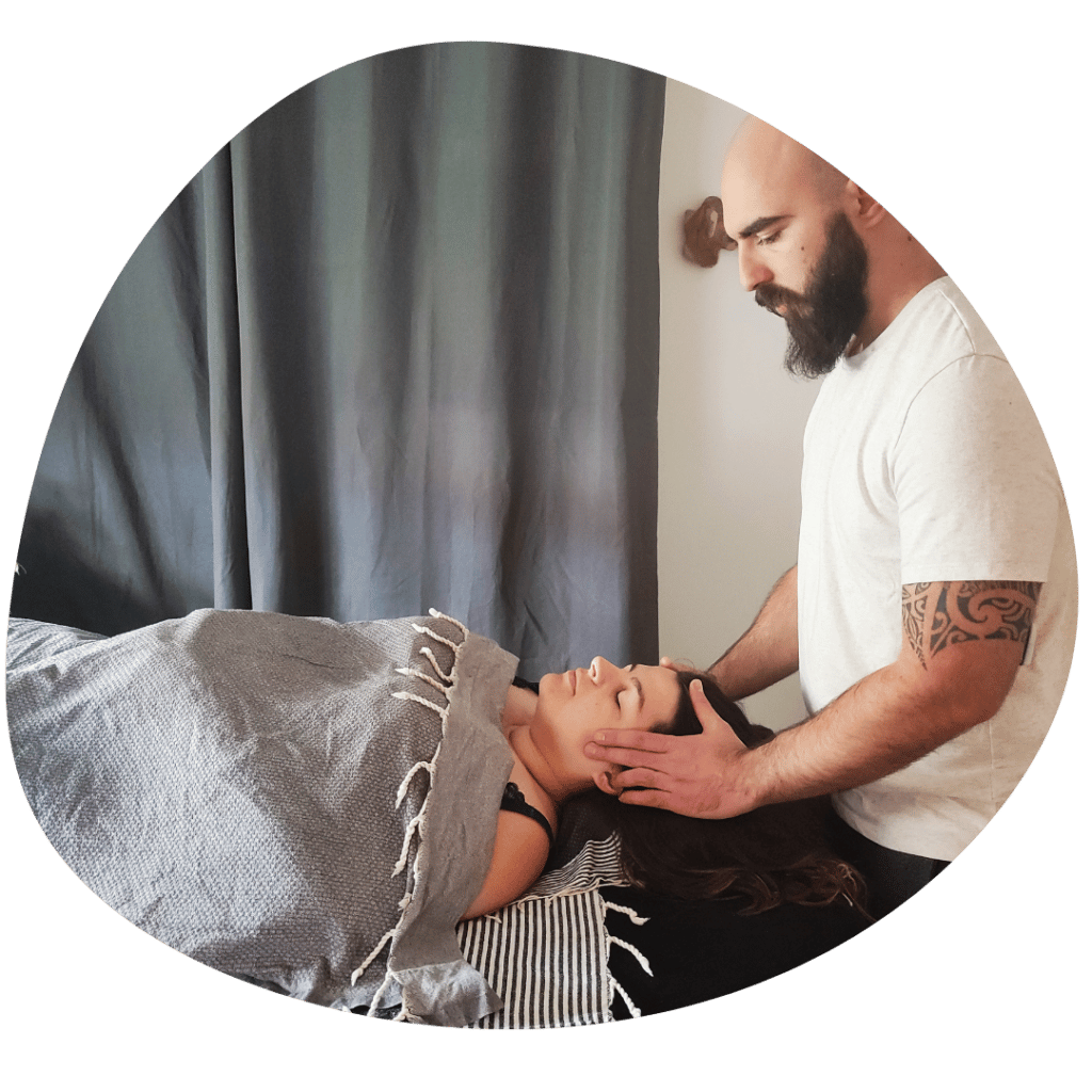 Un homme masse le visage d'une initiée de l'atelier collectif de massage à Pontonx